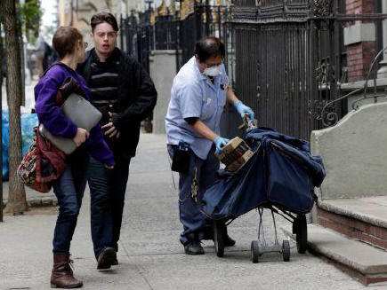 Postal worker Keven Ngo, wearing a protective mask and gloves, prepares to deliver to the apartment building of Ebola patient Dr. Craig Spencer, in New York, Friday, Oct. 24, 2014.