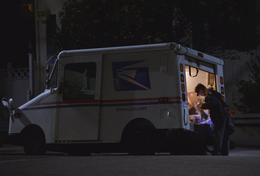 A postal worker makes his rounds in Oakland, Calif., on Monday, Dec. 19, 2016. (Kristopher Skinner/Bay Area News Group)