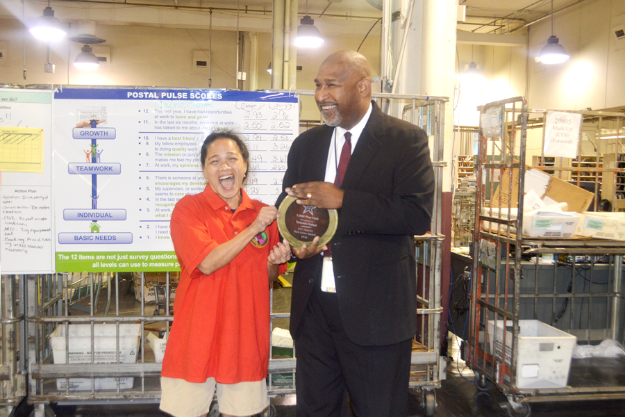 Greenville, SC, Custodian Yolanda Habal, who has accumulated more than 3,000 hours of sick leave, receives recognition recently from Greater South Carolina District Manager Darryl Martin.